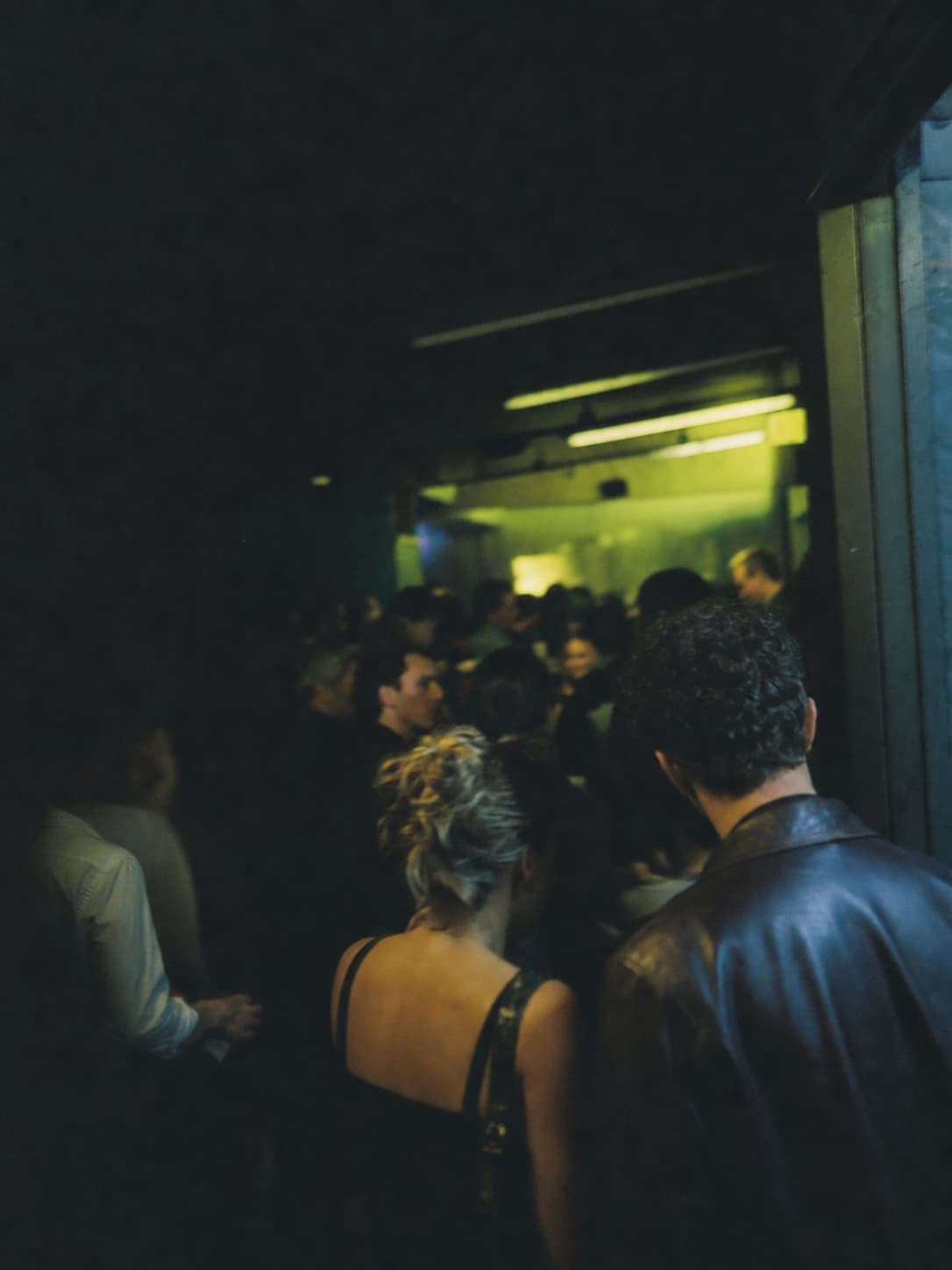 Friends crossing into a low-lit Toronto nightlife crowd