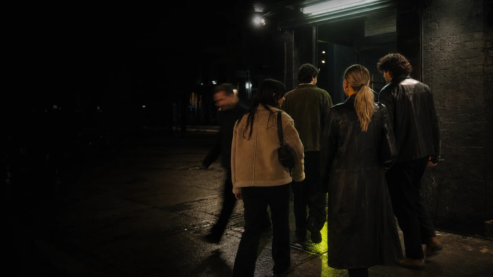 Friends arriving at a low-lit Toronto bar after dark